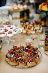 Mini tarts with whipped cream or custard and fresh berries. Homemade dessert. Copy space.