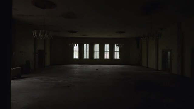 Entering an abandoned ballroom with minimal lighting  