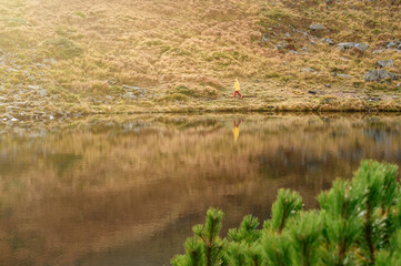 Light waves on Lake Nesamovite, a reflection in the water of a woman, a girl walking near Lake Nesamovite in bright clothes.
