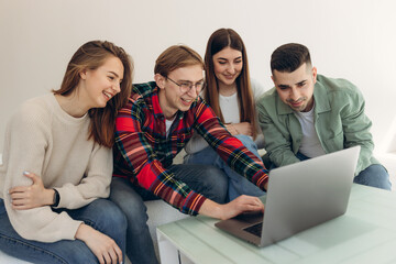 Group of friends looking at something on a laptop computer