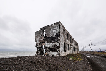 Destroyed building on the ocean shore. Post-apocalyptic industrial landscape