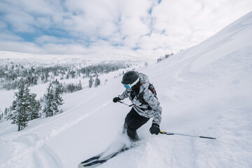 Skier female moving in snow powder in forest on a steep slope of  ski resort. Freeride, winter...