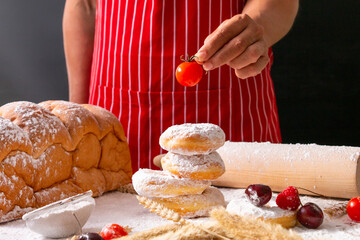 Hand of a man making homemade bread and donut on wooden table in his house.