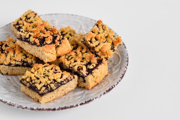 square cookies with jam on a white plate. White plate with cookies on the left side. Place for text