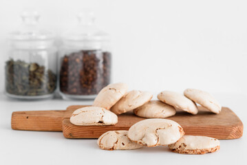 Delicious meringue. Meringue on a white background. Meringue on a wooden board in the foreground. Coffee beans on a background. Tea. Green tea. Horizontal photo.