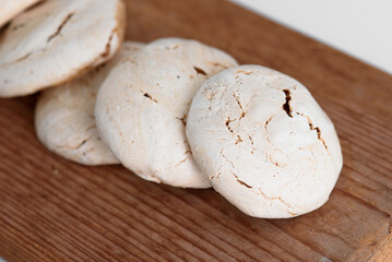 Close up of meringue. Meringue on a brown board. Chocolate meringue with stains.