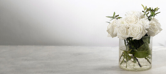 banner with bouquet of white roses on a white background with space for text. roses with green...