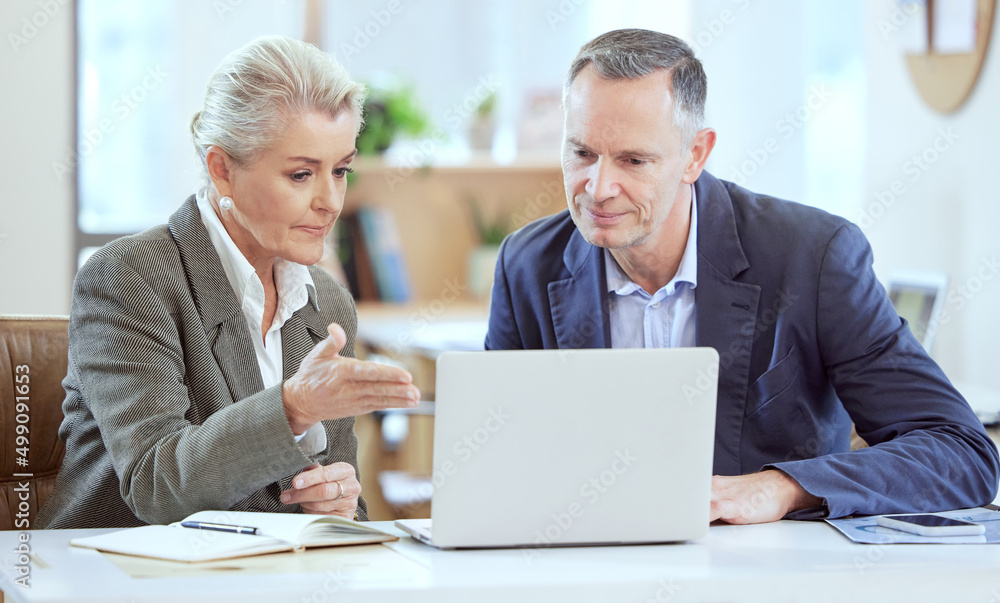Poster this is what were working with. shot of two businesspeople using a laptop together in an office at w