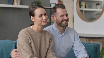 Happy Couple having Conversation while Sitting on Sofa 