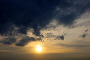 Sky covered with dark storm clouds and setting sun. Dramatic background for weather before rain at sunset