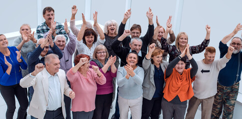 group of mature friends raised their hands up and celebrate succ