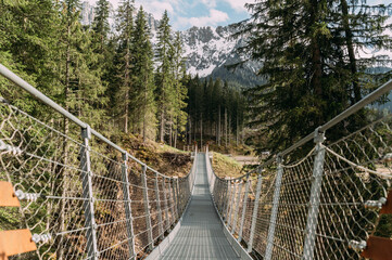 lange Hängebrücke aus Stahl mit schneebedeckten Bergen von Südtirol im Hintergrund in den Dolomiten in Südtirol