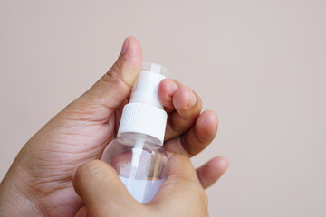 Women's hands using alcohol spray or antibacterial spray to prevent the spread of germs, bacteria and viruses.