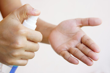 Women's hands using alcohol spray or antibacterial spray to prevent the spread of germs, bacteria and viruses.