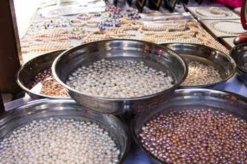 Chinese pearls. Bowls with water full of peals of different tints for sale in Xian, China. Close up of shiny pearls.