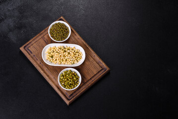 Organics fresh Baby Green Bean Sprouts in white ceramic bowl on a dark concrete background
