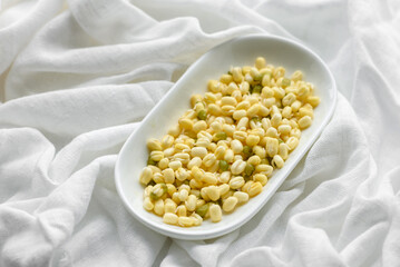 Organics fresh Baby Green Bean Sprouts in white ceramic bowl on a dark concrete background