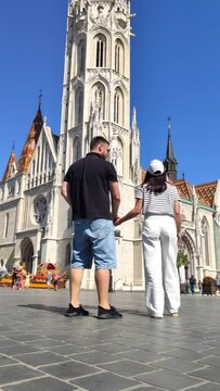 man with woman travelers taking picture in front of old european church at Budapest Hungary