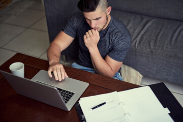 Hes got the discipline to work from home. Shot of a driven young man using his laptop to work from home.