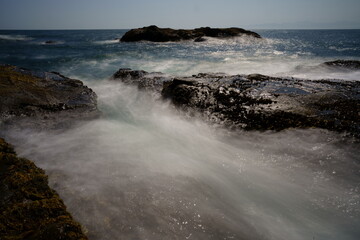 波が打ち寄せる岩場の海岸の風景をスローシャッターで撮
