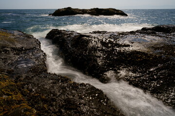 波が打ち寄せる岩場の海岸の風景をスローシャッターで撮