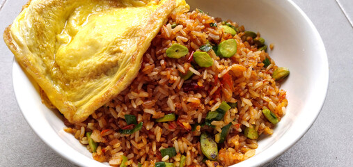 Traditional asian food fried rice with pete and omelette on top