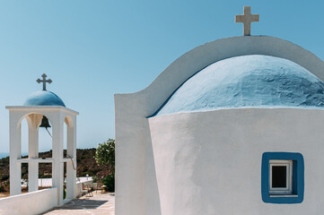 weisse Kirche mit blauen Kuppeln und Kreuz vor blauen Himmel  in Griechenland auf der Insel Kos 