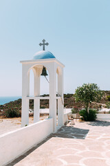 weisse Kirche mit blauen Kuppeln und Kreuz vor blauen Himmel  in Griechenland auf der Insel Kos 