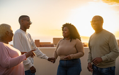 Happy African family having fun on rooftop during sunset time