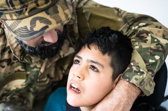 Military soldier hugging his son with disability at home