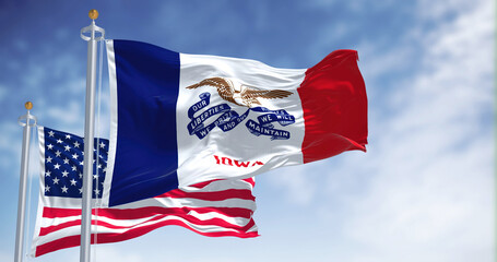 The Iowa state flag waving along with the national flag of the United States of America