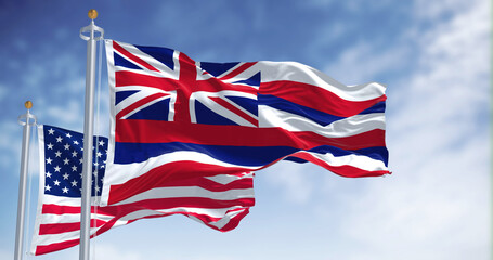 The Hawaii state flag waving along with the national flag of the United States of America.
