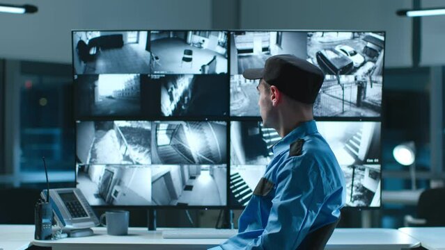 Portrait of security guard looking at camera with cctv cameras multiscreen on background