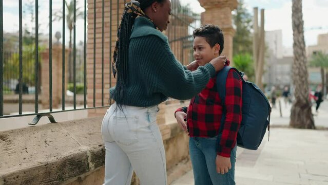 African american mother and son smiling confident kissing at street