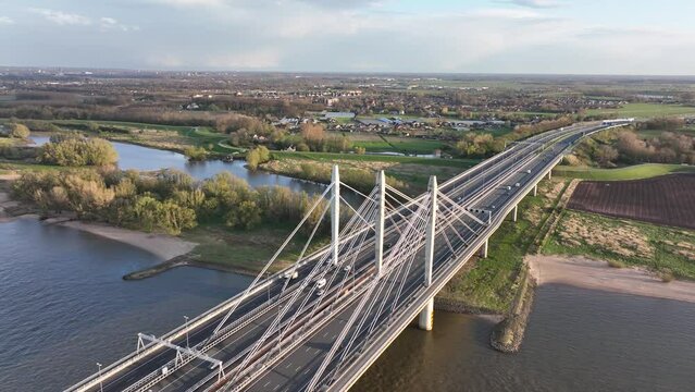 Tacitusbrug bij Ewijk modern suspension bridge crossing the river Waal near Nijmegen, the Netherlands Holland Europe. Valburg and Ewijk. Traffic highway over waterway. Holland.