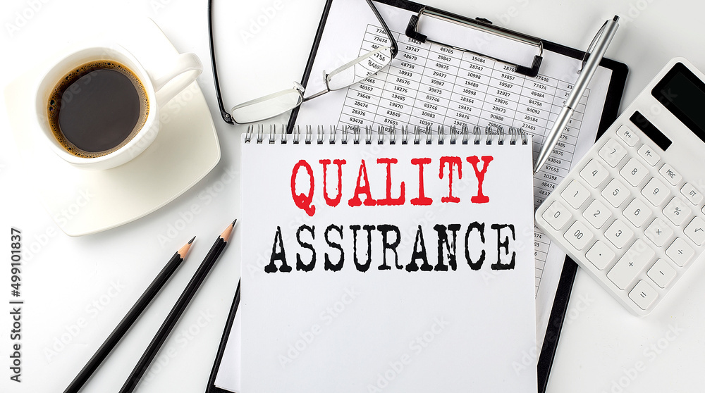 Poster quality assurance text on the paper with calculator, notepad, coffee ,pen with graph