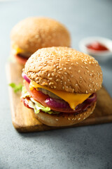 Traditional homemade cheeseburgers with pickles