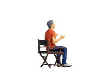 Miniature people sitting on chair isolated on white background and clipping path
