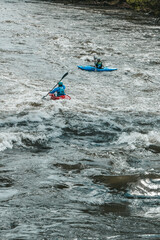 Canoeing on a river in Austria. Kayaking on a river with a big current.