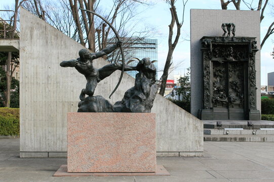 TOKYO, JAPAN - March 2, 2017: Two sculptures in front of the Le Corbusier-designed National Museum of Western Art in Tokyo: Bourdelle`s `Hercules the Archer` and Rodin`s `The Gates of Hell'. 