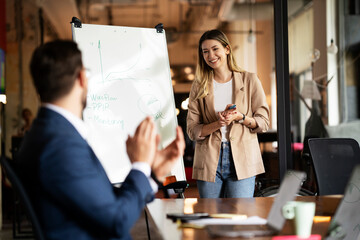 Businesswoman present her idea to working team. Young beautiful woman presenting businessplan..