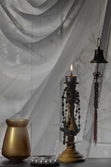 Study at the window. Sea rynda (bell), chandelier, bijouterie, cross.Symbols of the state of siege during the war in Ukraine. 