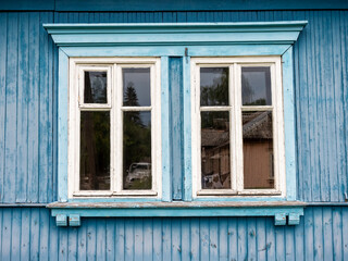 Fototapeta na wymiar White wooden window on a blue wooden wall, Warsaw, Poland