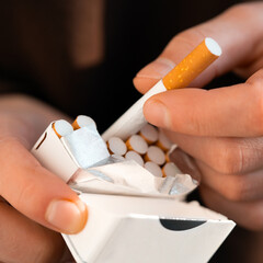 Male hands hold a pack of cigarettes, closeup view.
