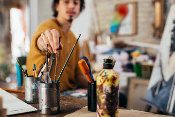 man painting picture in his atelier