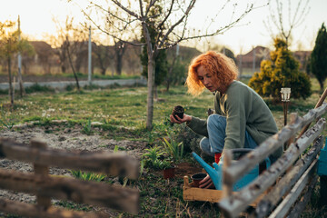woman gardening vegetables and herbs in her backyard