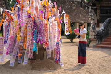 Asian Buddhist women pray, and make merit at Wat Ton Kain temple is the old wooden temple a famous place religious travel destination in Chiang Mai, Thailand.