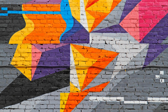 Colorful (purple, blue orange, yellow, grey, black and pink) brick wall as background, texture