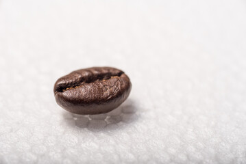 Roasted coffee beans on a white background. Styrofoam. Round texture.