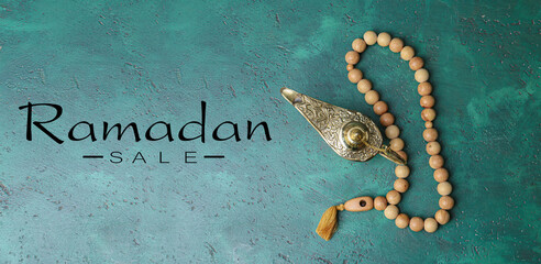 Muslim lamp, prayer beads and text RAMADAN SALE on green background, top view